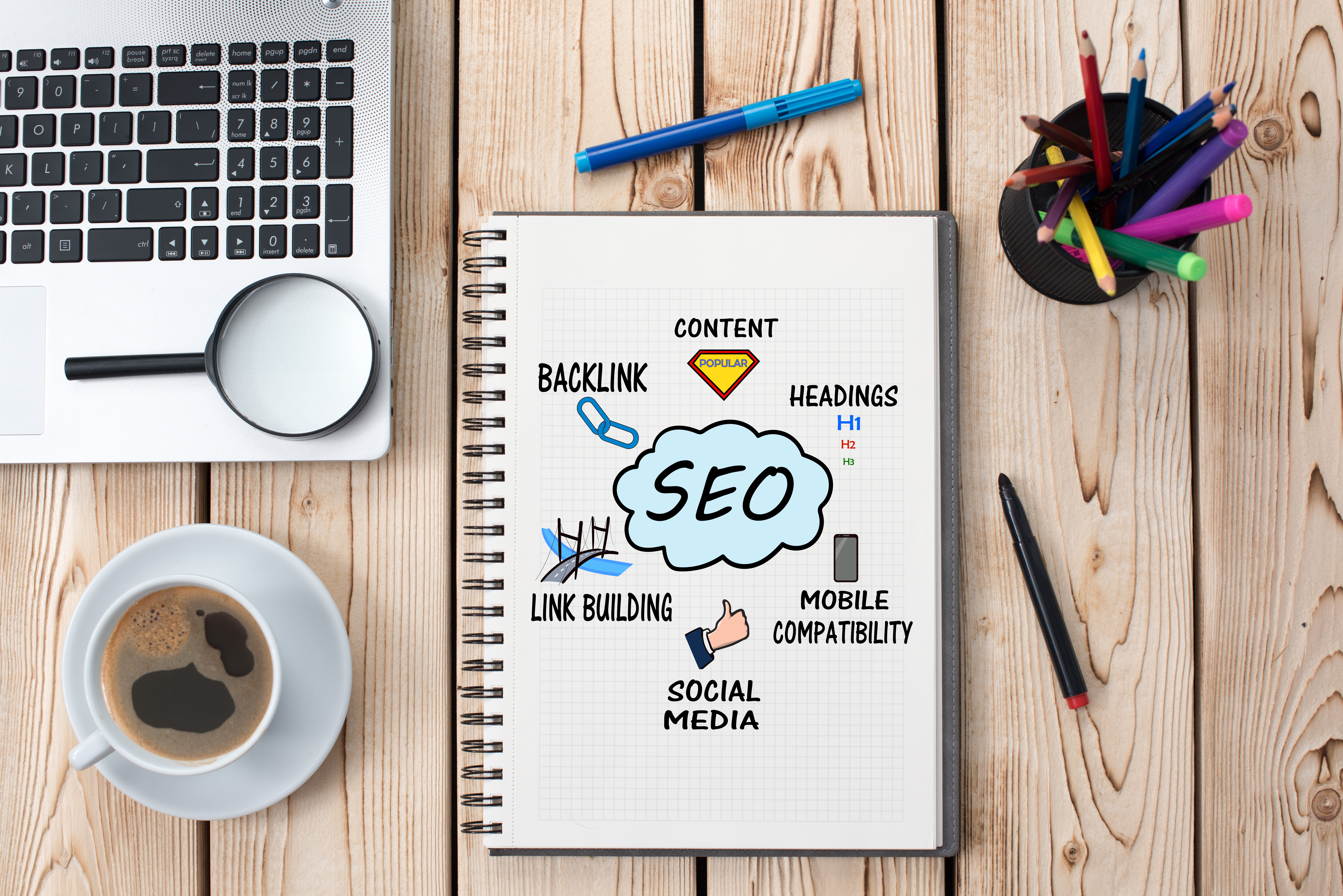 Image of a generic desk with an open notebook that reads SEO