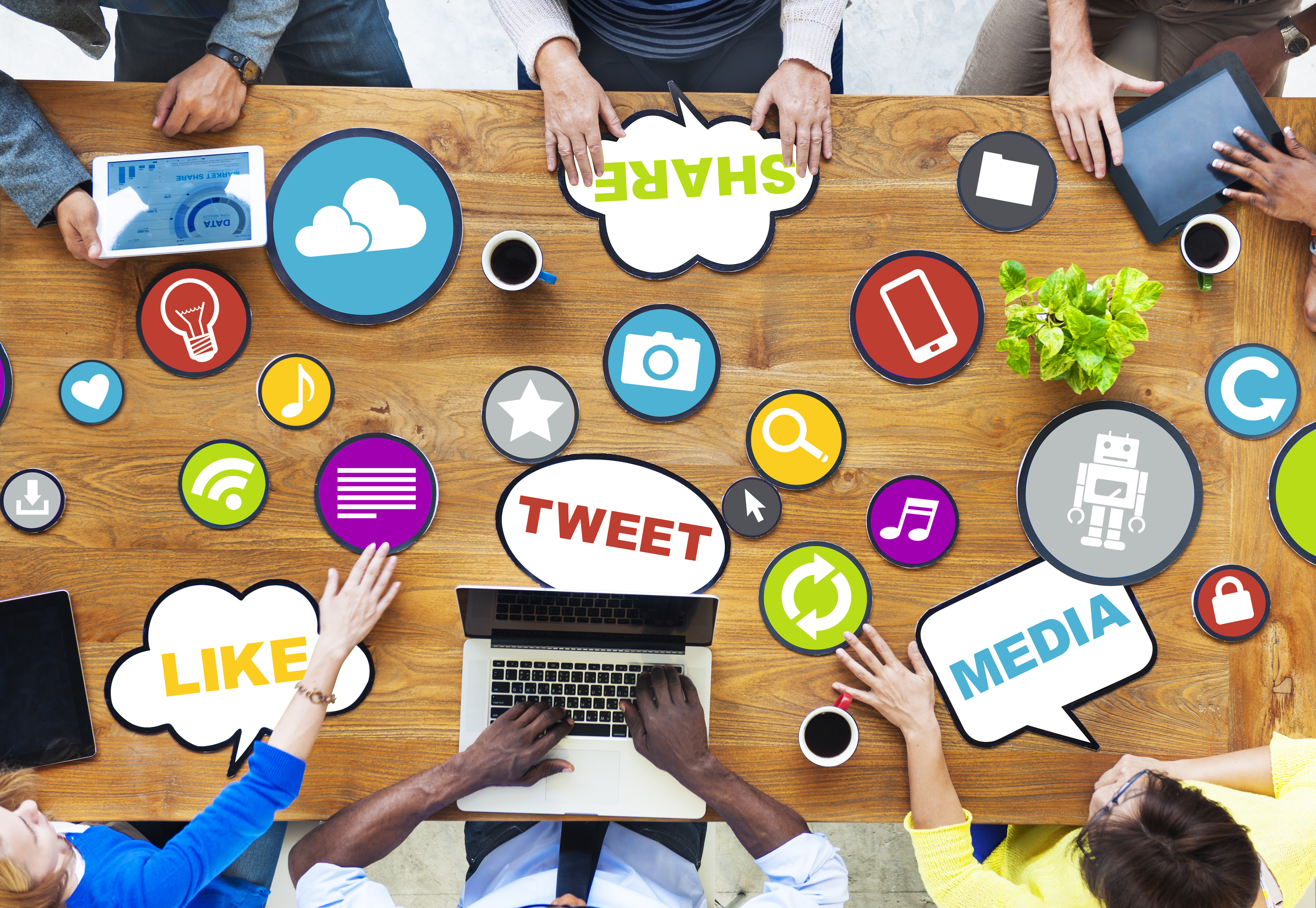 Image of a conference table with words and icons related to social media scattered across it.